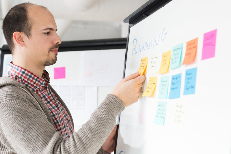 man in a shirt sticking post-it notes on a whiteboard hr consultant norwich norfolk peak performance hr