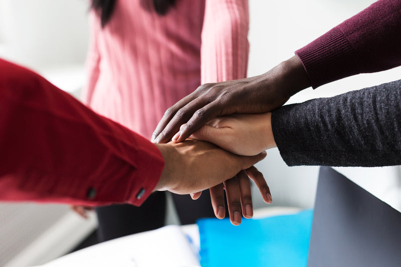 team hands on top of each other. professional development coaching norwich norfolk peak performance hr