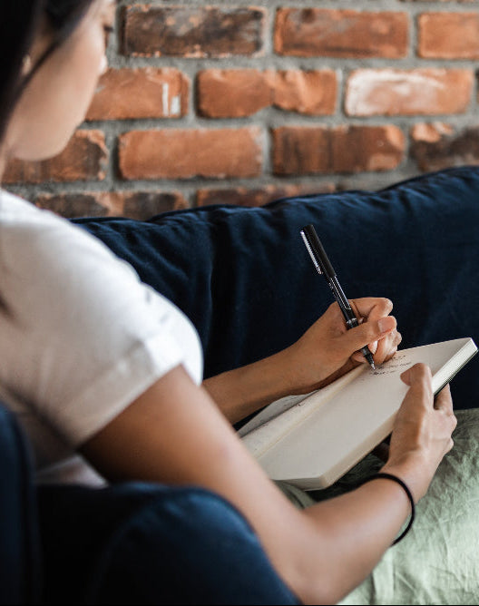 lady sitting on sofa writing in a notebook workplace resilience workshop Norwich Norfolk peak performance hr